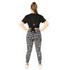 Black open back tee from Milbel Active - back view of girl modelling knotted black tee top and floral leggings